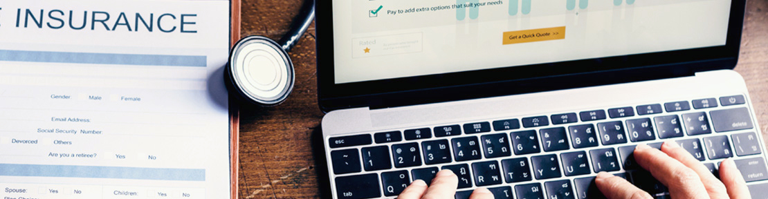 Hands at laptop, reviewing insurance options